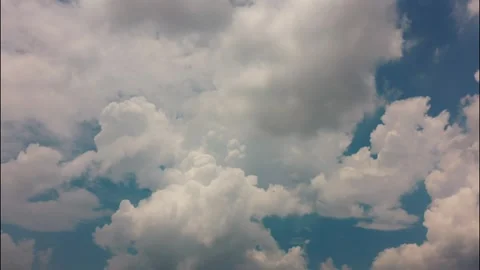 White puffy clouds drifting across a bright blue sky during a sunny afternoon Stock Footage 340902294
