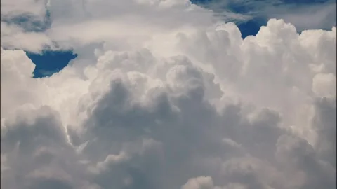 White puffy clouds drifting across a bright blue sky during a sunny afternoon Stock Footage 340902295