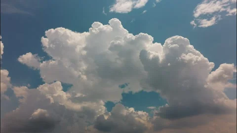 White puffy clouds drifting across a bright blue sky during a sunny afternoon Stock Footage 340902296