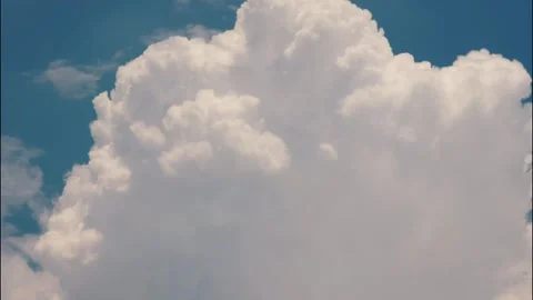 White puffy clouds drifting across a bright blue sky during a sunny afternoon Stock Footage 340902297