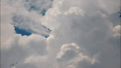 White puffy clouds drifting across a bright blue sky during a sunny afternoon Stock Footage 340902299