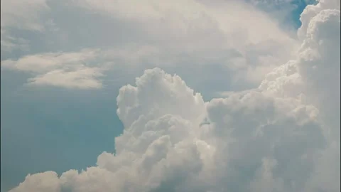 White puffy clouds drifting across a bright blue sky during a sunny afternoon Stock Footage 340902303
