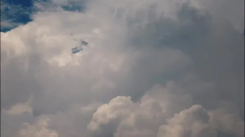 White puffy clouds drifting across a bright blue sky during a sunny afternoon Stock Footage 340902306