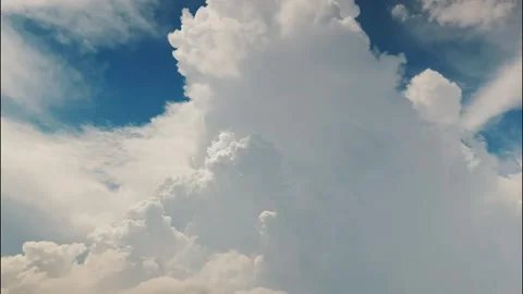 White puffy clouds drifting across a bright blue sky during a sunny afternoon Stock Footage 340902313