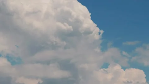 White puffy clouds drifting across a bright blue sky during a sunny afternoon Stock Footage 341562922