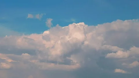 White puffy clouds drifting across a bright blue sky during a sunny afternoon 스톡 동영상 341562951