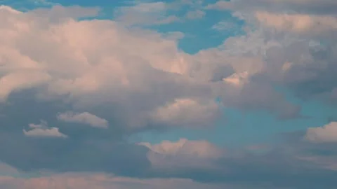 White puffy clouds drifting across a bright blue sky during a sunny afternoon Vídeo Stock 341562954