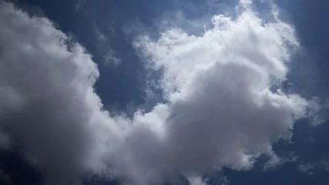 White puffy clouds move across a brilliant blue sky. 스톡 동영상 75794280