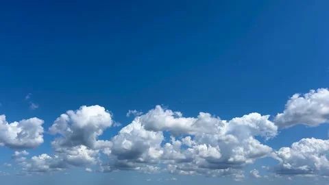 White puffy clouds moving across blue sky Stock Footage 330175958
