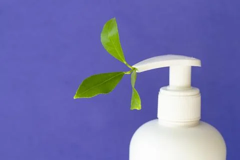A white pump bottle with a leaf inside the pump Stock Photos
