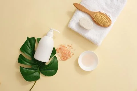 White pump bottle without label placed on a green leaf. A folded towel featur 写真素材