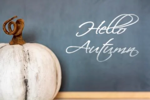 White pumpkin in front of blackboard. With the text Hello Autumn Stock Photos