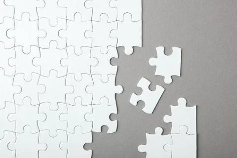 White puzzle on a colored background top view. Stock Photos