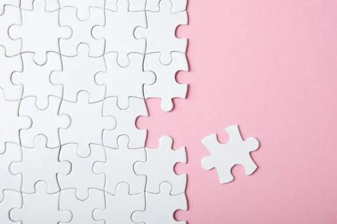 White puzzle on a colored background top view. Stock Photos