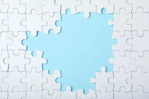 White puzzle on a colored background top view. Stock Photos