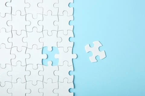 White puzzle on a colored background top view. Stock Photos