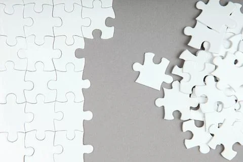 White puzzle on a colored background top view. Stock Photos