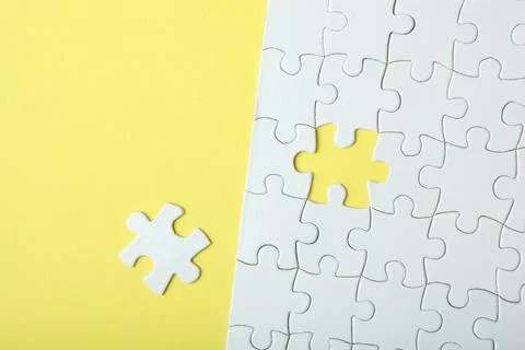 White puzzle on a colored background top view. Stock Photos