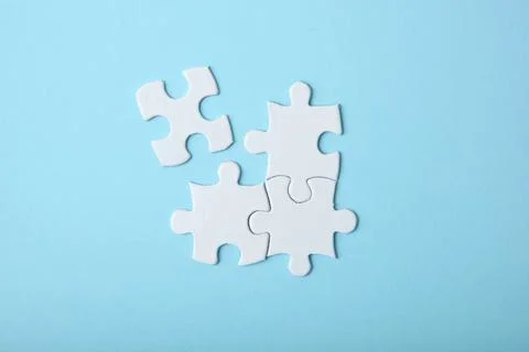 White puzzle on a colored background top view. Stock Photos