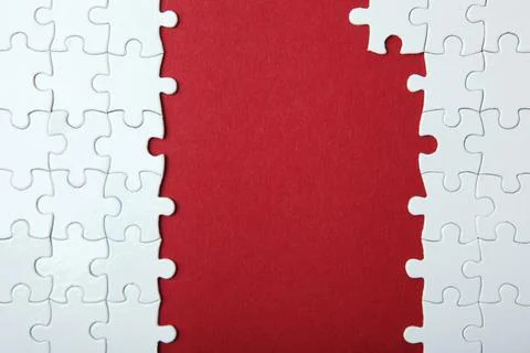 White puzzle on a colored background top view. Stock Photos