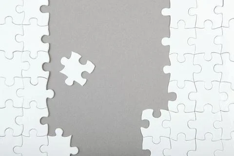 White puzzle on a colored background top view. Stock Photos