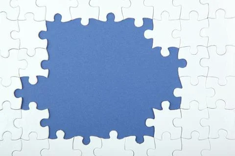 White puzzle on a colored background top view. Stock Photos