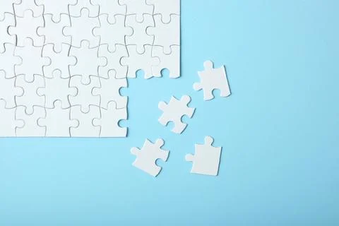 White puzzle on a colored background top view. Stock Photos