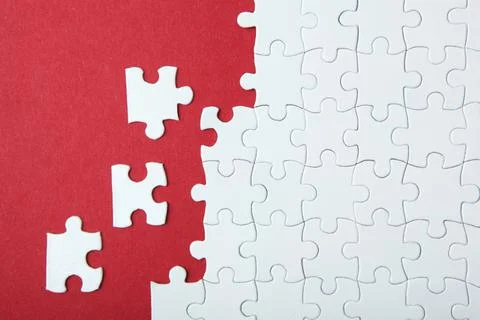 White puzzle on a colored background top view. Stock Photos