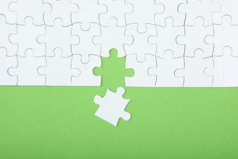 White puzzle on a colored background top view. Stock Photos