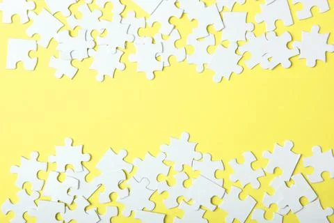 White puzzle on a colored background top view. Stock Photos