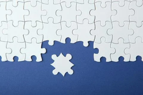 White puzzle on a colored background top view. Stock Photos