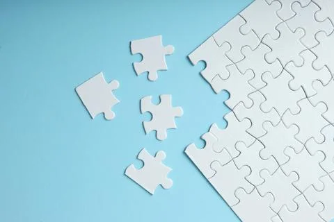 White puzzle on a colored background top view. Stock Photos