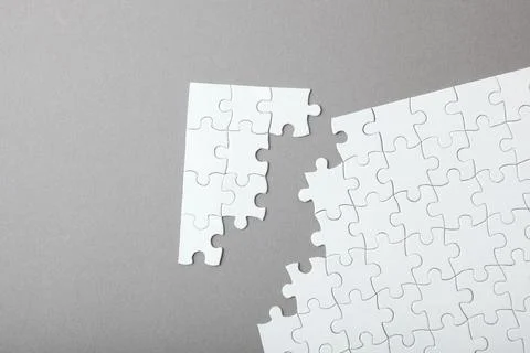 White puzzle on a colored background top view. Stock Photos