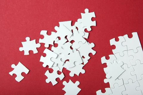 White puzzle on a colored background top view. Stock Photos