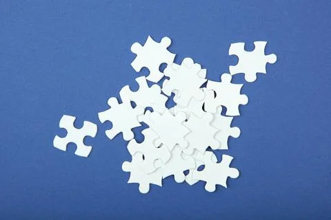 White puzzle on a colored background top view. Stock Photos