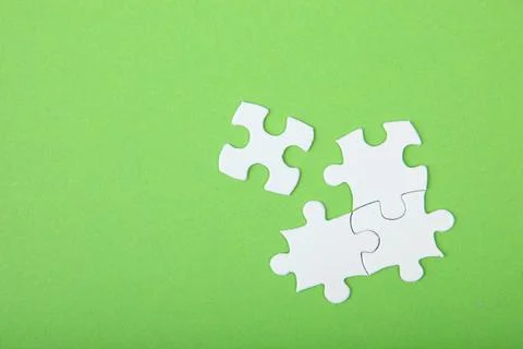 White puzzle on a colored background top view. Stock Photos