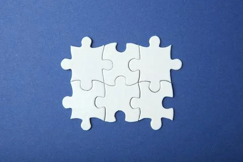 White puzzle on a colored background top view. Stock Photos