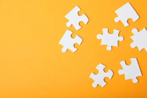 White puzzle on a colored background top view. Stock Photos