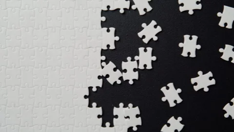 White puzzle elements assembled on black background indoor closeup top view Stock Footage 332309850
