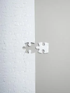 White puzzle with the final missing piece placed outside. Thinking outside .. Stock Photos