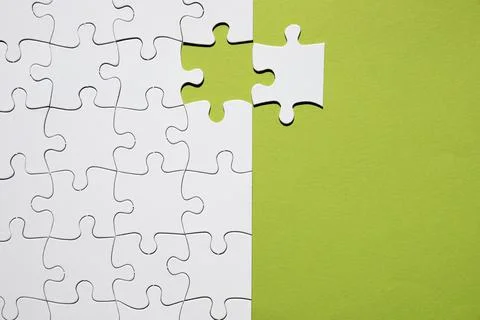 White puzzle piece separate with white puzzle grid green backdrop Resolution Stock Photos