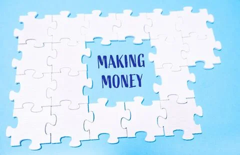 White puzzles on a blue background with the text MAKING MONEY Stock Photos