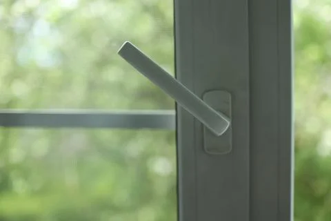White pvc window handle in the open position to allow climate control and fresh Stock Photos