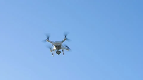 A white quadcopter appears on a background of blue sky and flies away. Video stock 161304690