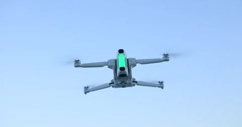 White Quadcopter Drone Flying in Clear Blue Sky Stock-Footage 343930854