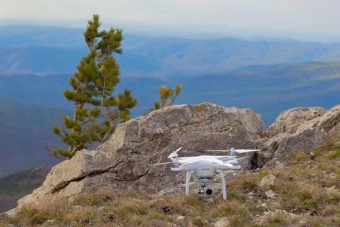 White quadcopter in the mountains Stock-Fotos