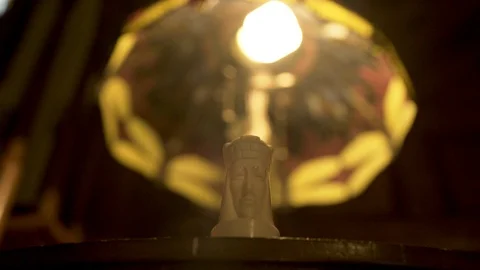 White queeen sitting on table in front of lamp Stock Footage 91159640