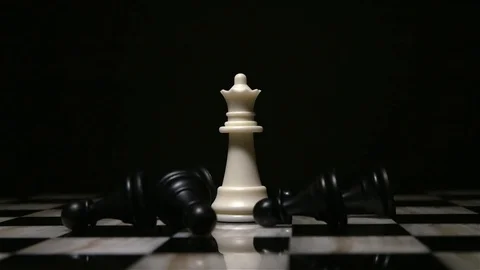 White queen piece surrounded by fallen black pawns Stock Footage 92525634