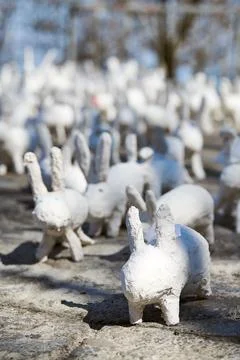 White rabbit statues made of plaster at outdoor art exhibition, funny white h Stock Photos