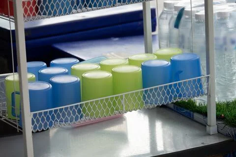 A white rack with a variety of colored plastic cups on it Stock Photos